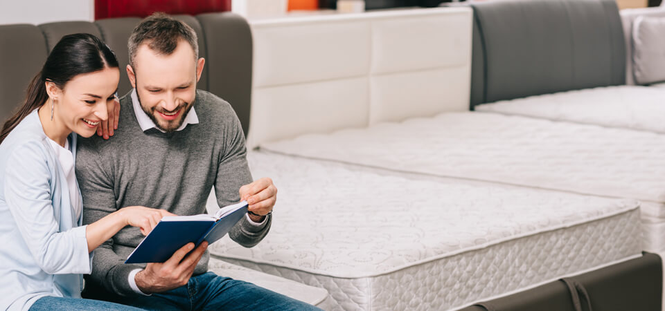 Pariskunta tarkastelee muistiinpanoja huonekaluliikkeessä.